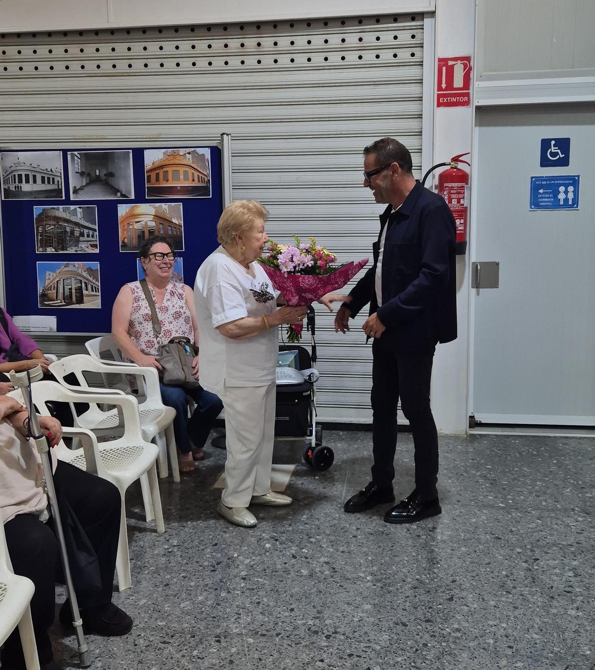 El lacalde, José Francico Cabanes, entrega un ramo de flores a Amparo Race.