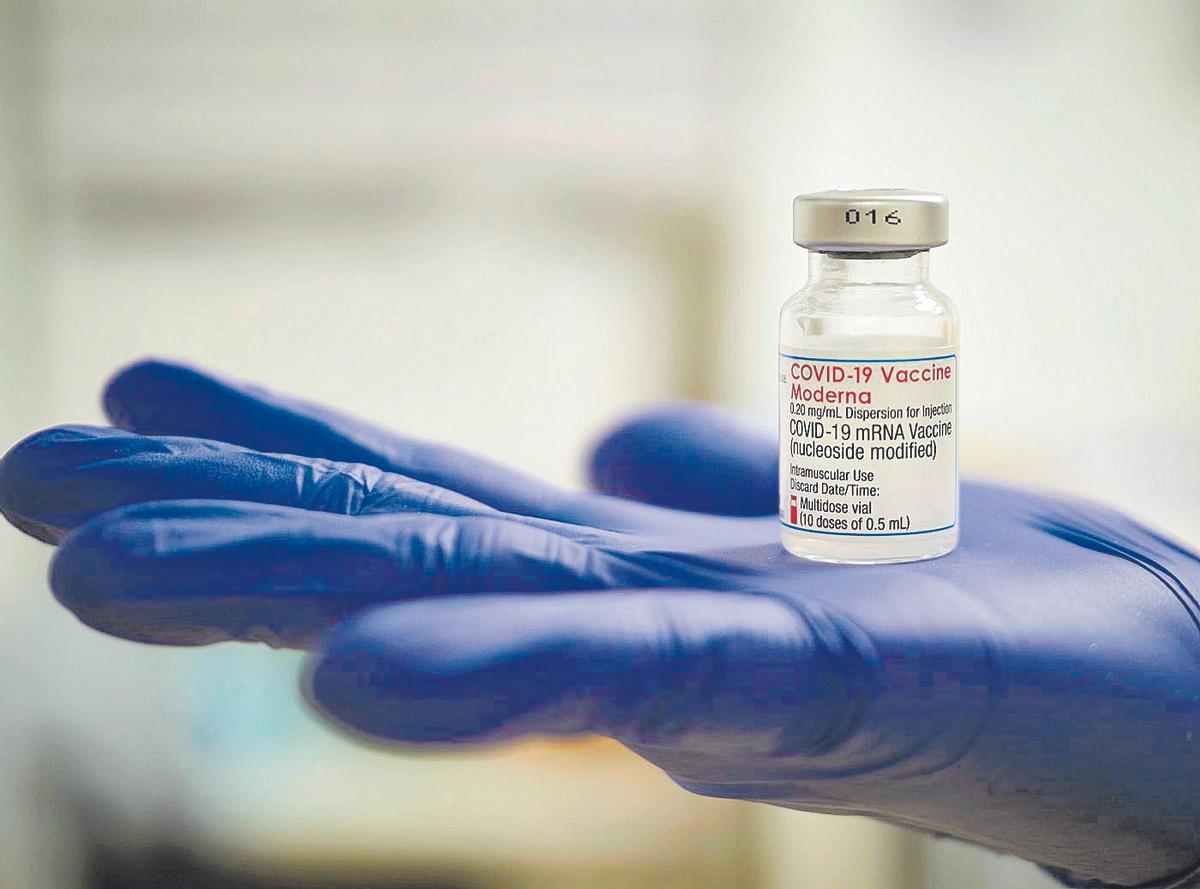 Una profesional sanitaria sostiene un vial de la vacuna de Moderna contra el covid durante la pandemia.