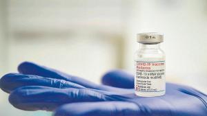 Una profesional sanitaria sostiene un vial de la vacuna de Moderna contra el covid durante la pandemia.