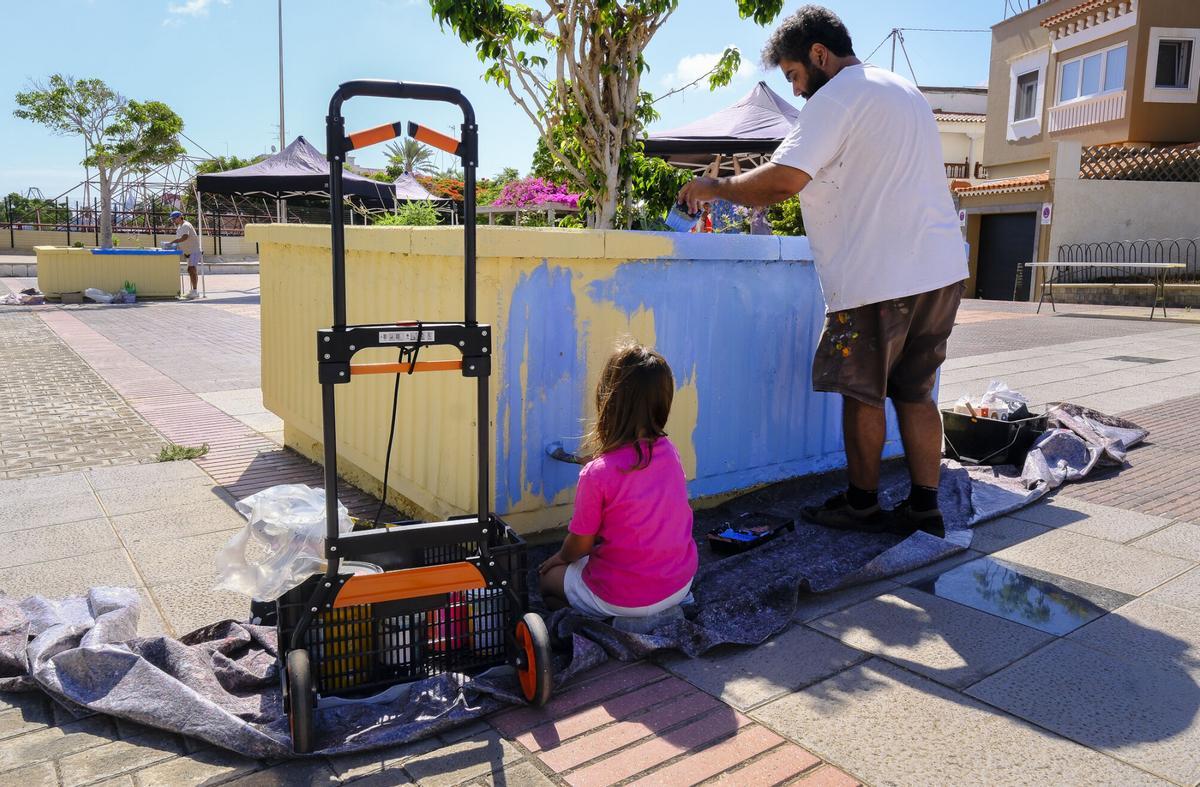 Sophie Roda, de cinco años, colabora con la pintura de un macetero en la plaza Gabriel Megías Pombo.