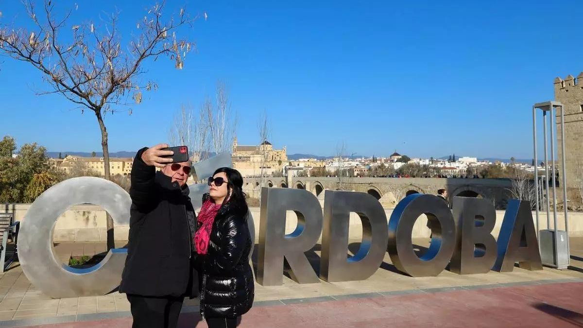 Varias personas se fotografían junto a las letras de Córdoba en la Torre de la Calahorra.