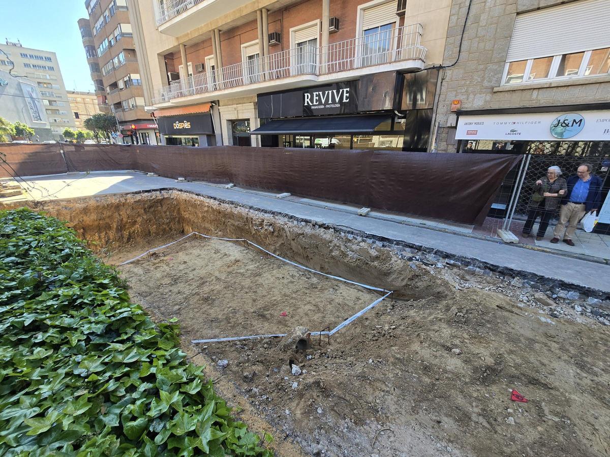 Dos pacenses observan los restos arqueológicos encontrados en la avenida de Huelva de Badajoz.