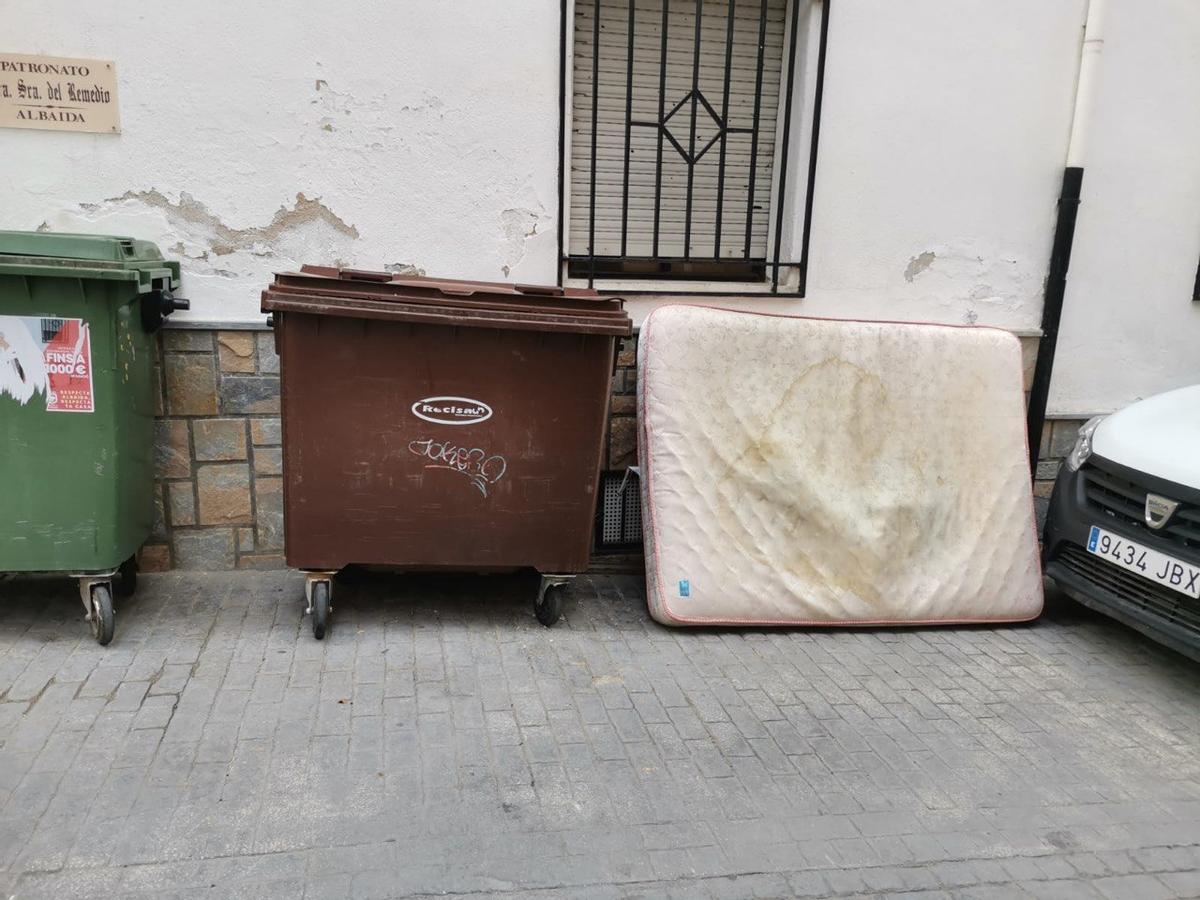 Un colchón depositado junto a un contenedor en Albaida.