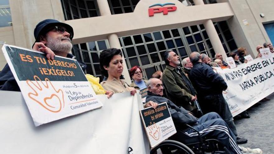 Miembros de la Plataforma en defensa de la Ley de Dependencia se ha concentrado hoy ante la sede del PP en Valencia.