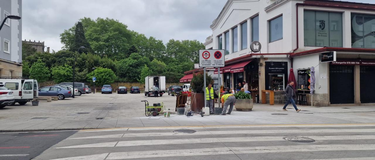 Dos operarios colocando una señal en la zona peatonal situada ante la plaza de abastos, ayer. |   // M. Méndez