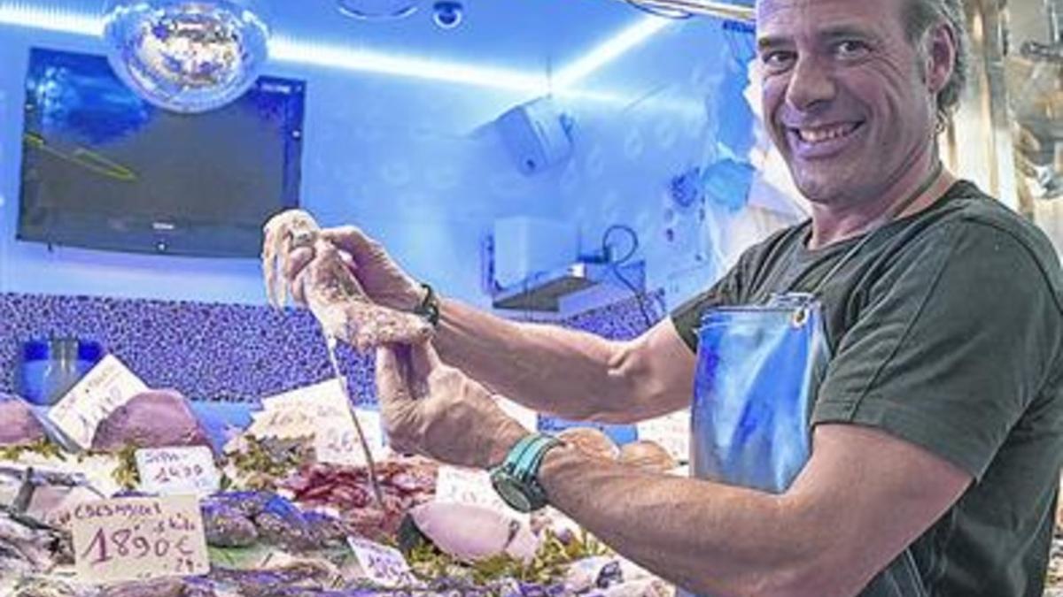 Leandro G. Cervera posa con un calamar en su puesto de La Llibertat.