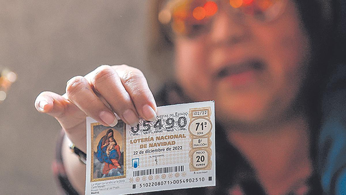 Una mujer enseña un décimo premiado de la Lotería de Navidad.