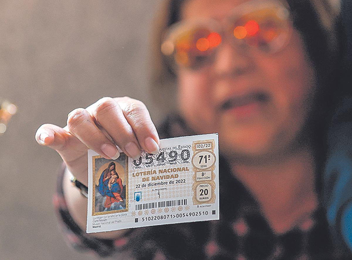 Una mujer enseña un décimo premiado de la Lotería de Navidad.