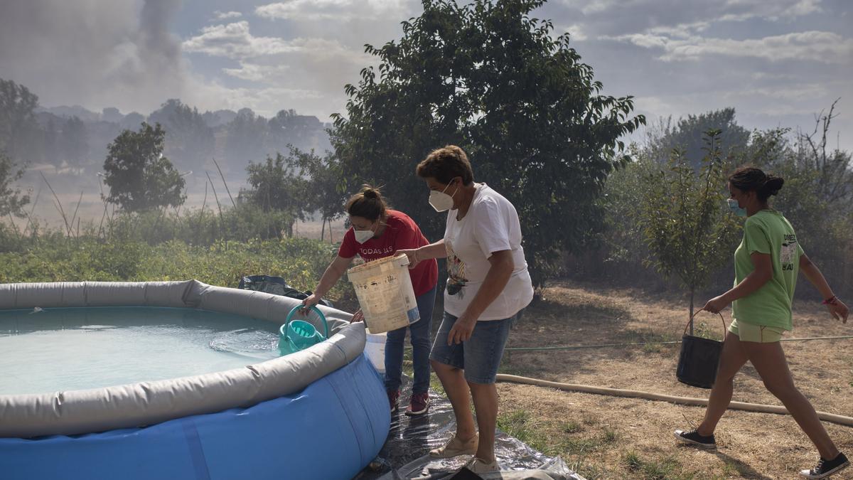 Vecinos cogen agua de una piscina en el incendio originado en Lober de Aliste.