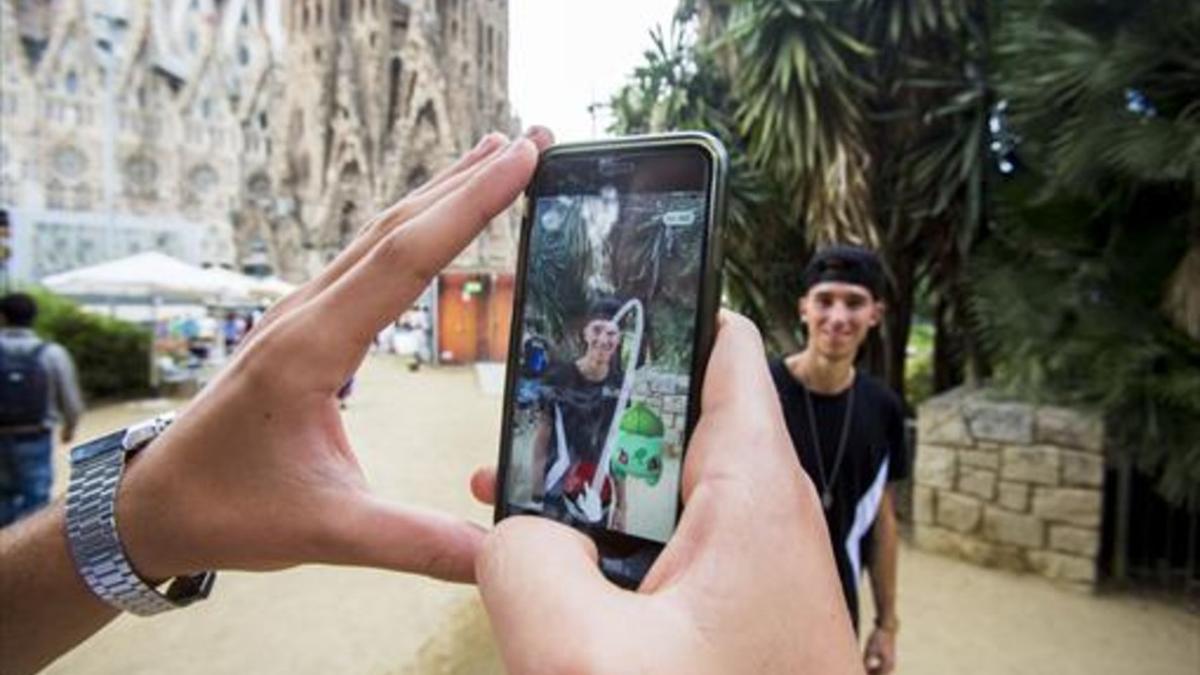 Dos usuarios de Pokémon Go frente a la Sagrada Família.