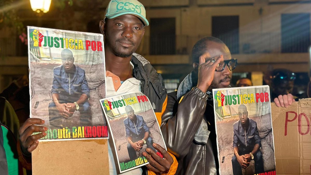 Dos hombres sostienen pancartas con imágenes del rostro de Mamouth Bakhoum.