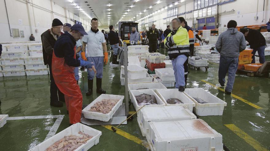 Trabajadores de O Berbés manipulan cajas de pescado distribuidas por la cooperativa. // Ricardo Grobas