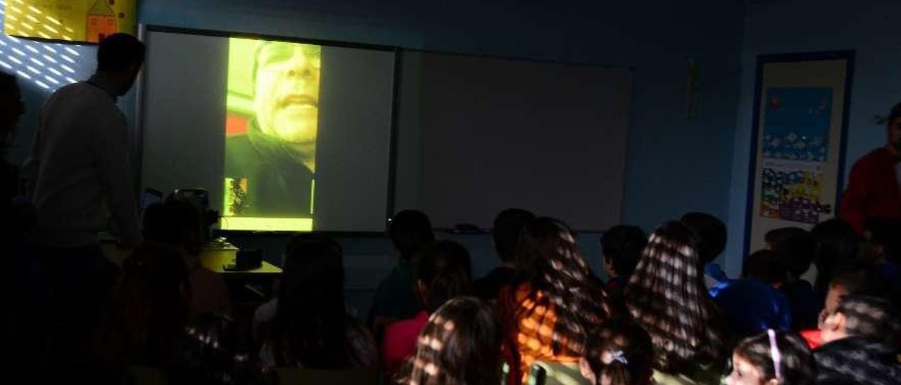 Joan Riba, en la imagen del proyector, habla, ayer, con los alumnos del colegio de Beluso. // Gonzalo Núñez