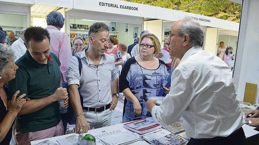 El presidente de Ledo del Pozo (a la derecha) atendiendo a autoridades y visitantes en la Feria del Libro.