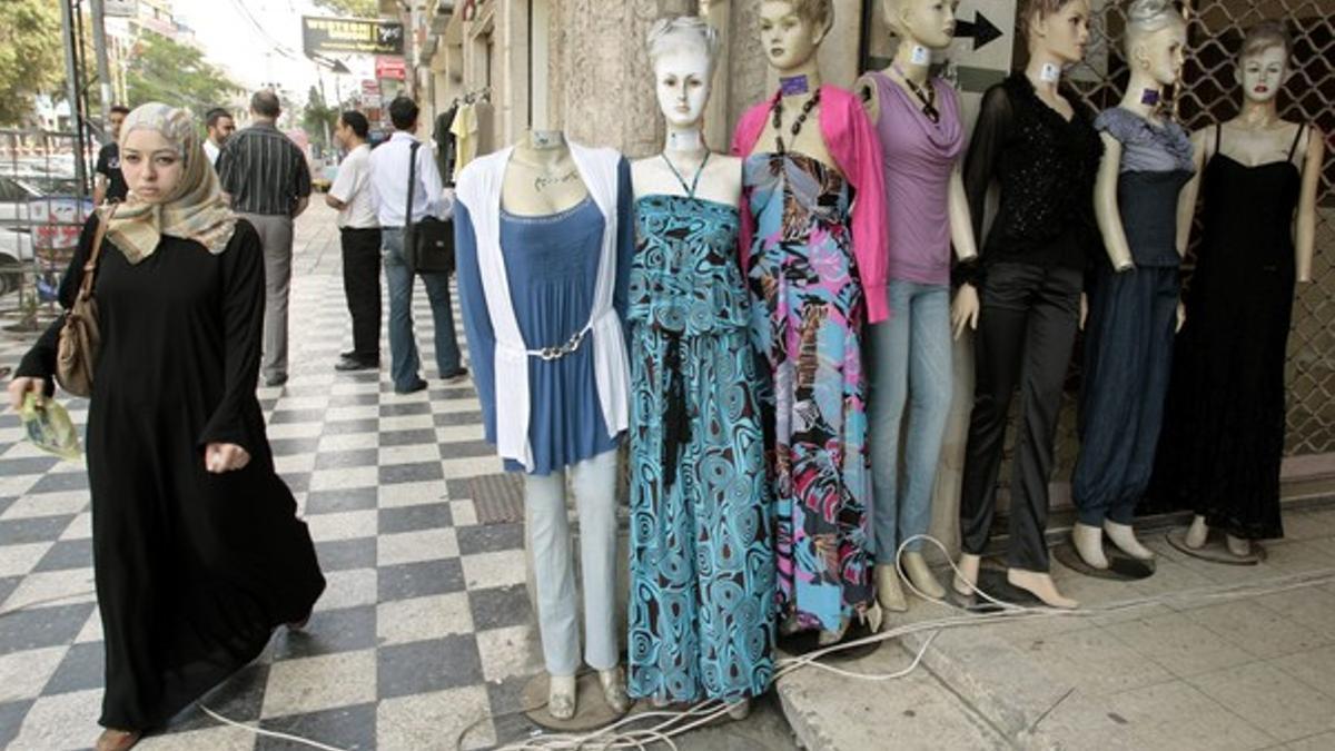 Una mujer palestina junto a unos maniquís en Gaza.