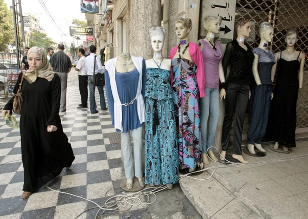 Una mujer palestina junto a unos maniquís en Gaza.