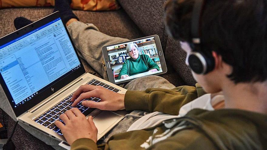 Un estudiante siguen una clase online desde su casa.