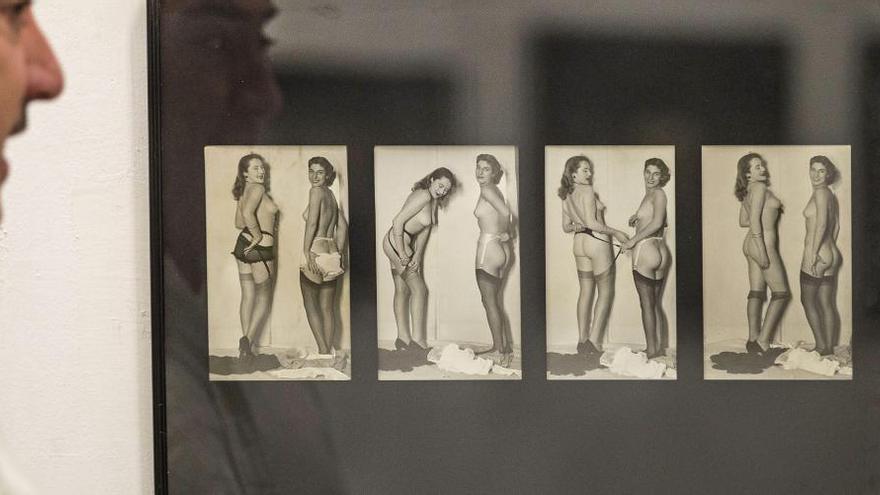 Un hombre observa una seria de fotografías eróticas de mediados del siglo pasado en la Galería Raylowski.