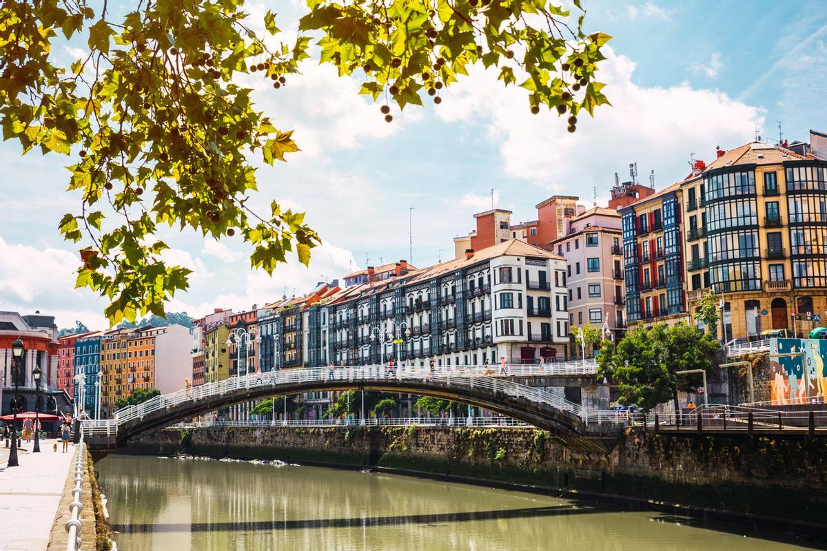 El centro de Bilbao con el río Nervión, el puente de la Ribera y su colorida arquitectura en un día soleado.