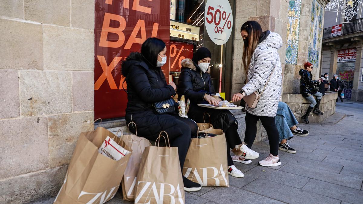 Jóvenes de compras en las rebajas por el centro de Barcelona