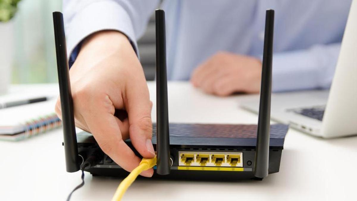 Una persona conecta un router.