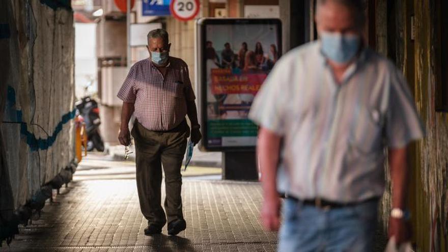 Un hombre pasea por Santa Cruz de Tenerife con mascarilla.