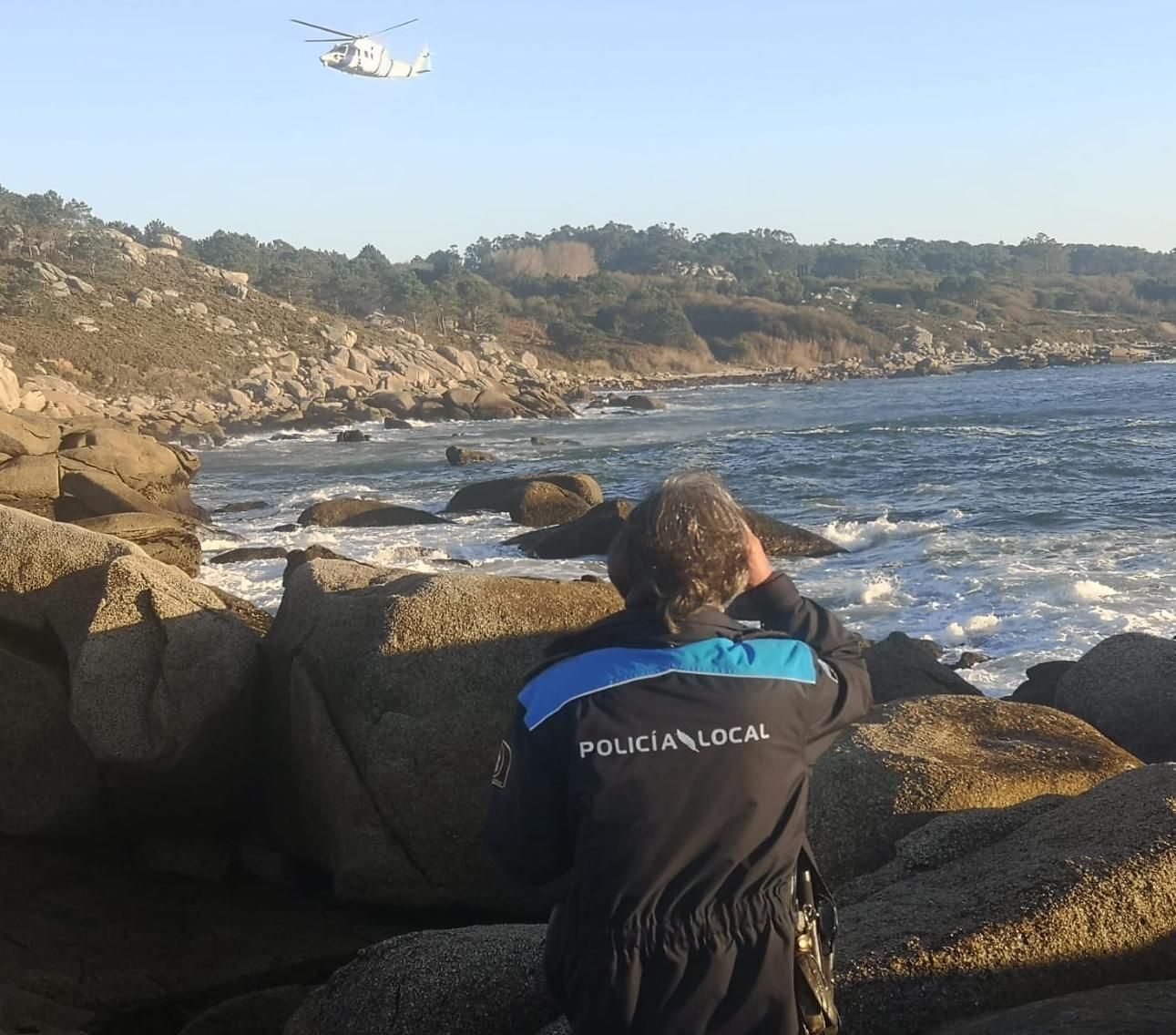 El helicóptero Pesca 1 y un agente de la Policía Local de O Grove, durante la búsqueda.