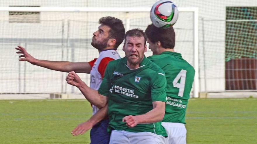 Un jugador del Alondras intenta despejar el balón ante dos rivales. // Gonzalo Núñez