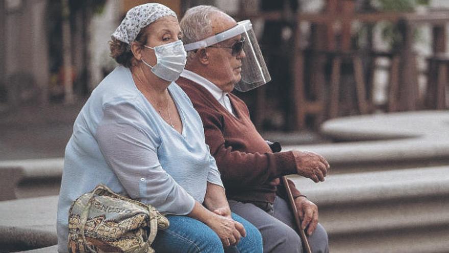 Dos vecinos bien protegidos ante el Covid, en el centro de Santa Cruz de Tenerife.