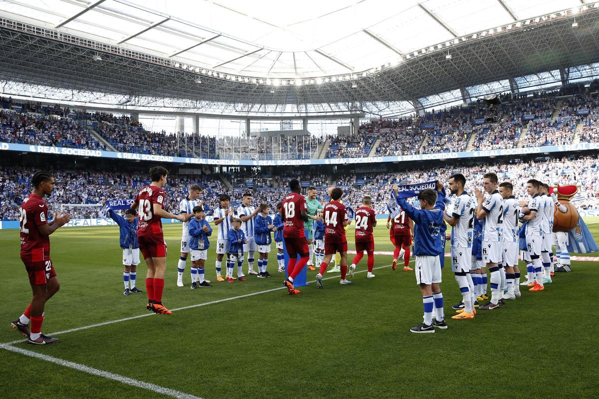 SAN SEBASTIÁN, 04/06/2023.- Los jugadores de la Real Sociedad hacen el pasillo a los campeones de la Liga Europa, el Sevilla FC, antes del partido de la última jornada de Liga que Real Sociedad y Sevilla FC disputan hoy domingo en el Reale Arena de la capital donostiarra. EFE/Juan Herrero