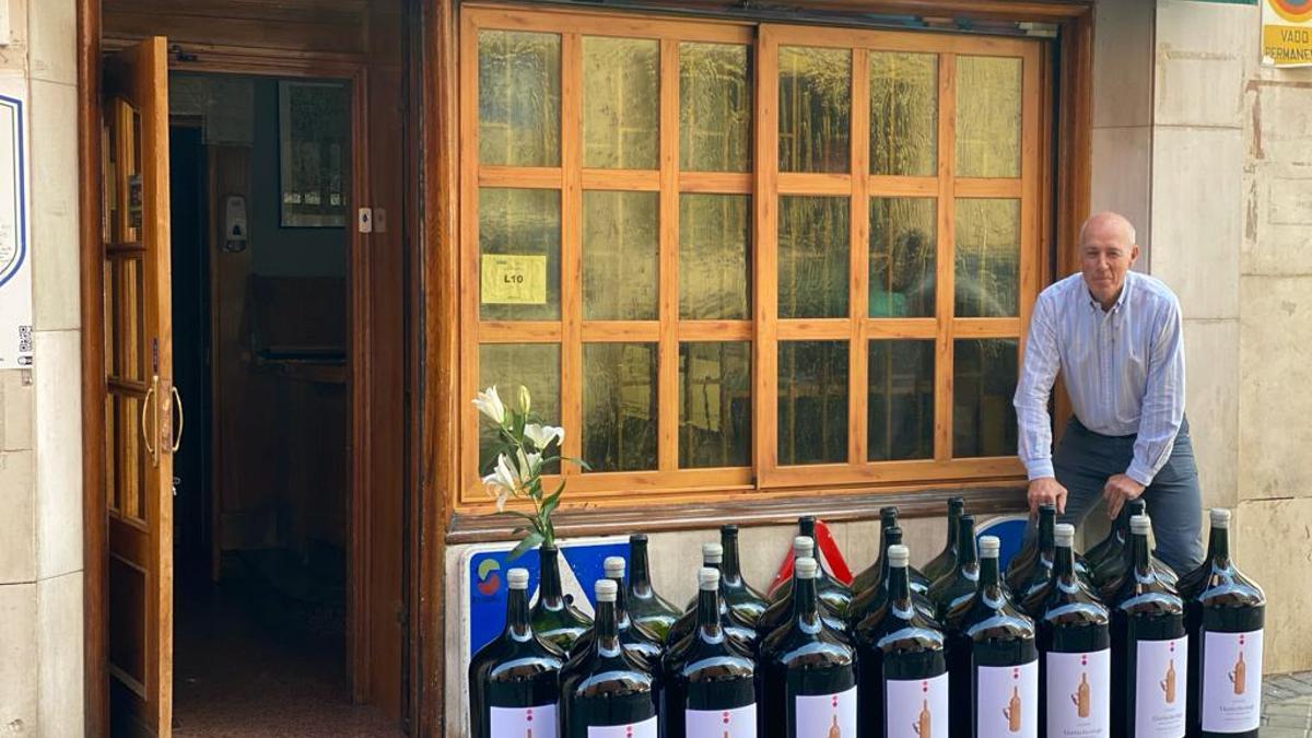 Pepe Morán en la puerta de De la Riva con sus botellas de vino de 27 litros
