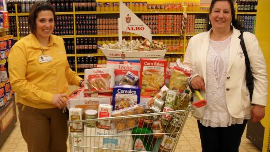 Covadonga Sánchez, encargada del supermercado Alimerka de la calle del Rosal, de Oviedo, entrega su premio a María Teresa Rodríguez, de Tudela Veguín.