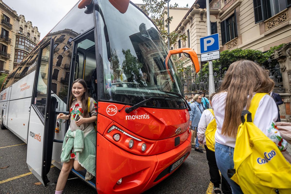 Una niña participante del proyecto 'Vacaciones de Paz', baja del autobús, este martes en Barcelona.