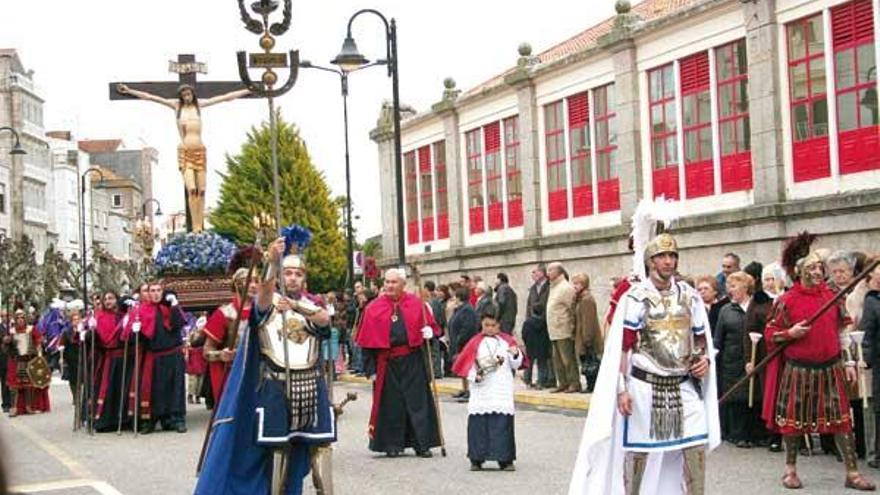 Legionarios romanos, cofrades y penitentes acompañaron la imagen del Cristo en su recorrido por el centro urbano de Cangas.