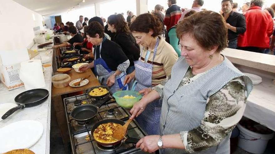 Vecinas de Nespereira elaboran tortillas, ayer en la fiesta. // R. Grobas