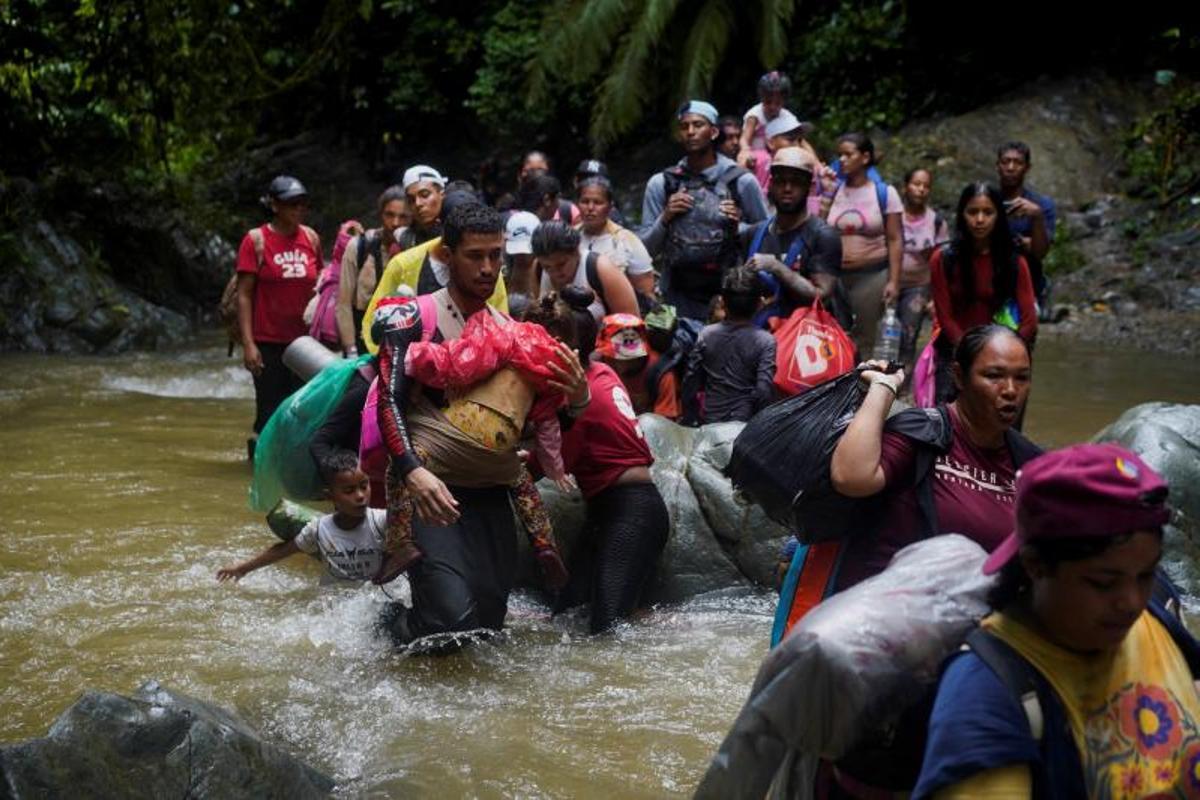 Migrantes cruzan el río Muerto en el Tapón del Darién, de viaje hacia los Estados Unidos, en Acandi, Colombia