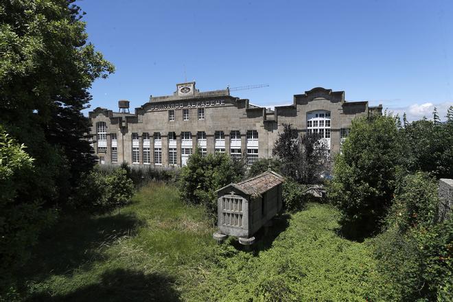 Fachada principal de la factoría, con el hórreo y el frente ajardinado.