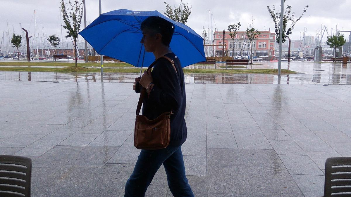 Una mujer pasea por la Marina un día lluvioso.