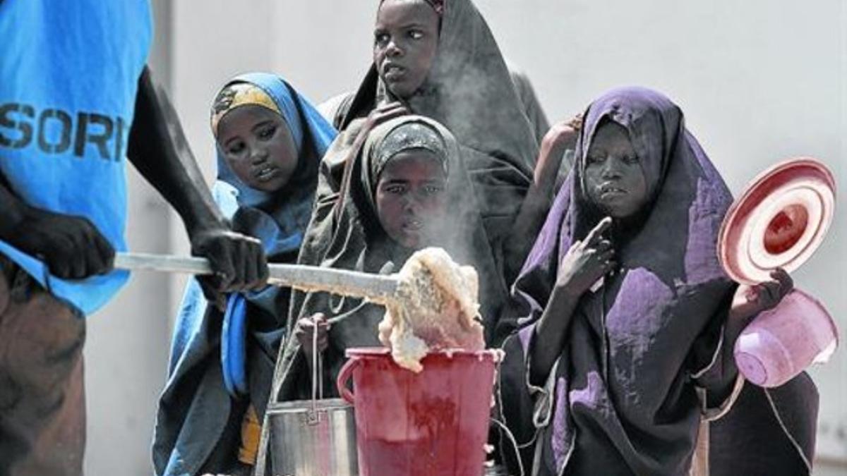 Niños refugiados somalís reciben comida en un centro de distribución de la ONU en Mogadischo, en el 2012.