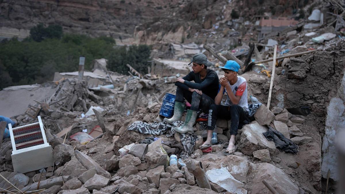 Dos adolescentes sentados sobre las ruinas de unas casas en la pequeña aldea de Imi N'Tala.