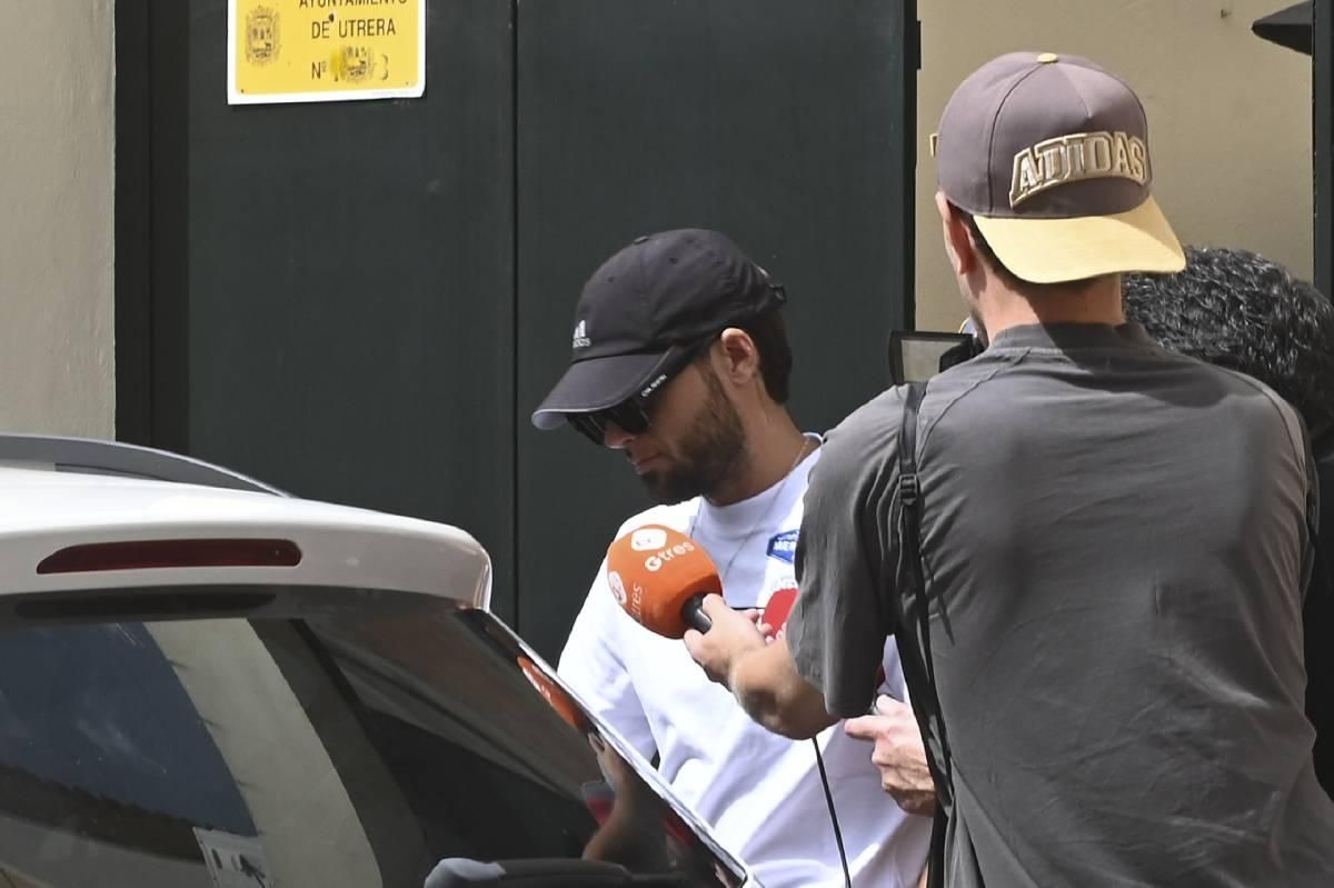 Montoya, cubierto con una gorra y gafas de sol, saliendo de la casa de sus padres en Utrera