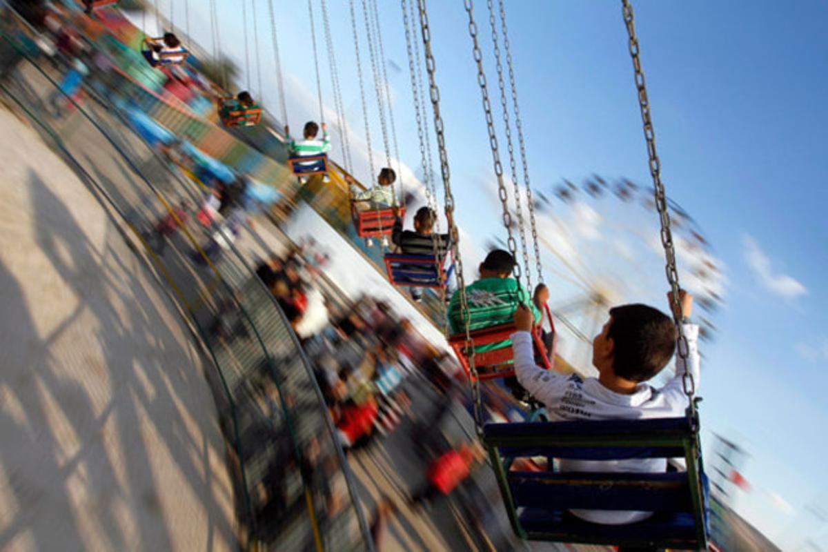 Nens palestins disfruten en un parc d’atraccions en el segon dia de la festivitat musulmana Eid al-Adha a Jenín (Cisjordània).
