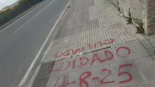 Una pintada avisa de una acera en mal estado en Eirís para evitar tropiezos