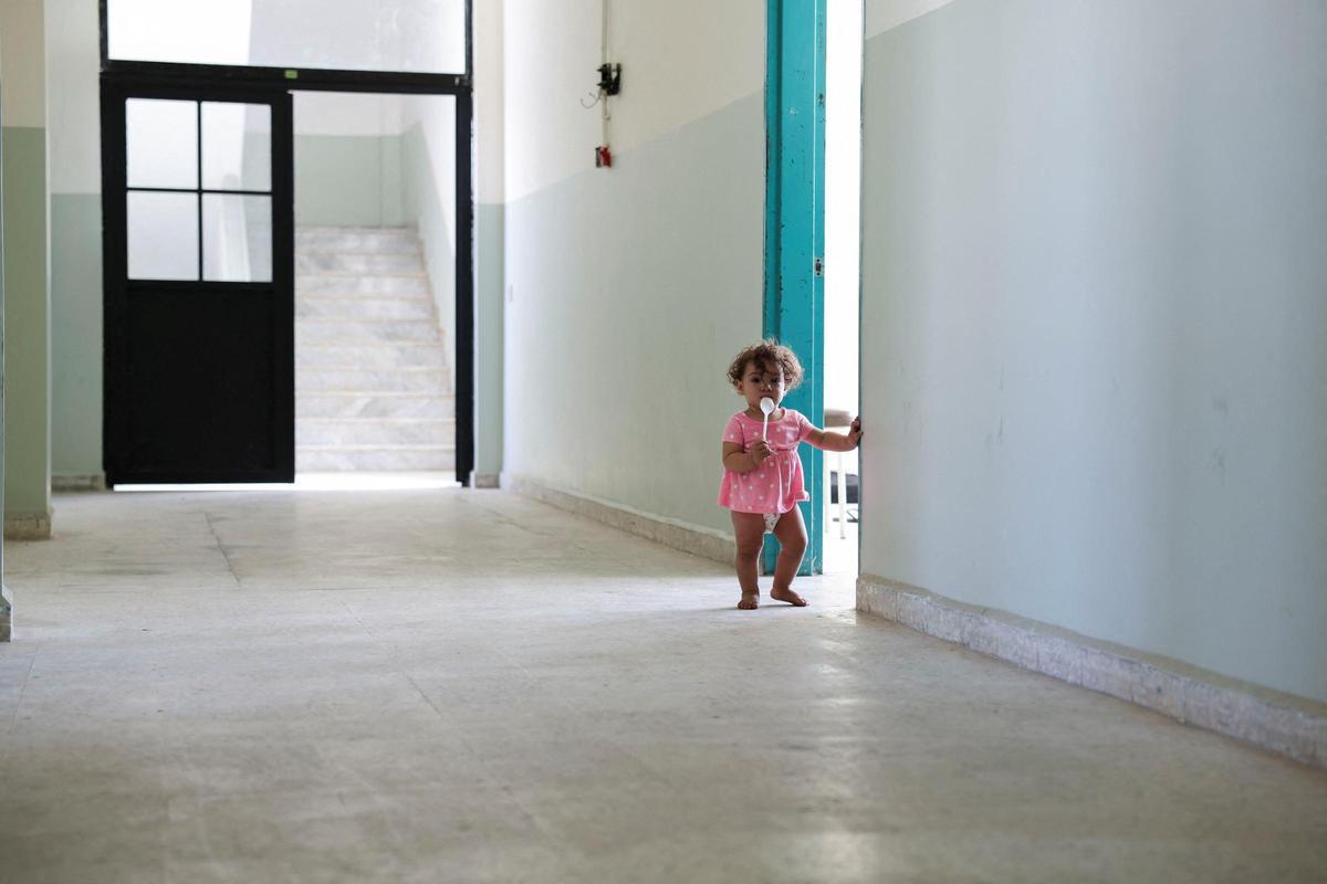 Una niña desplazada de zonas atacadas por Israel se asoma por una puerta de un instituto convertido en refugio en Beirut, este martes.