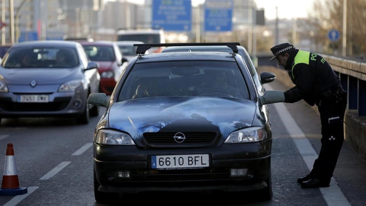 Un agente exige a un conductor con matrícula acaba en cero que dé media vuelta y no entre en Madrid, este jueves en la avenida de América.