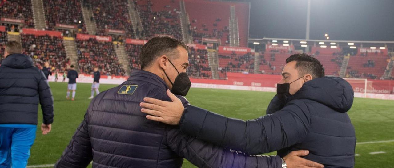 Luis García y Xavi se saludan al inicio del partido.