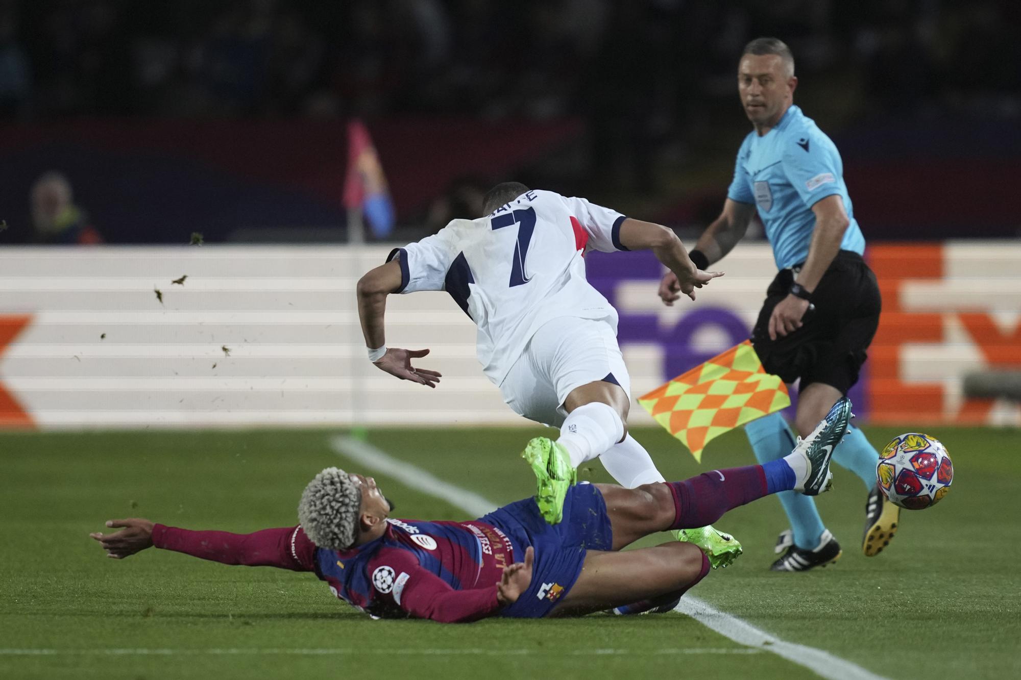 PSG's Kylian Mbappe, top, is challenged by Barcelona's Ronald Araujo during the Champions League quarterfinal second leg soccer match between Barcelona and Paris Saint-Germain at the Olimpic Lluis Companys stadium in Barcelona, Spain, Tuesday, April 16, 2024. (AP Photo/Emilio Morenatti)