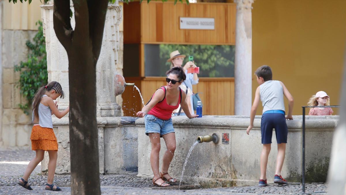 Turistas se refrescan en una fuente en el Patio de los Naranjos.