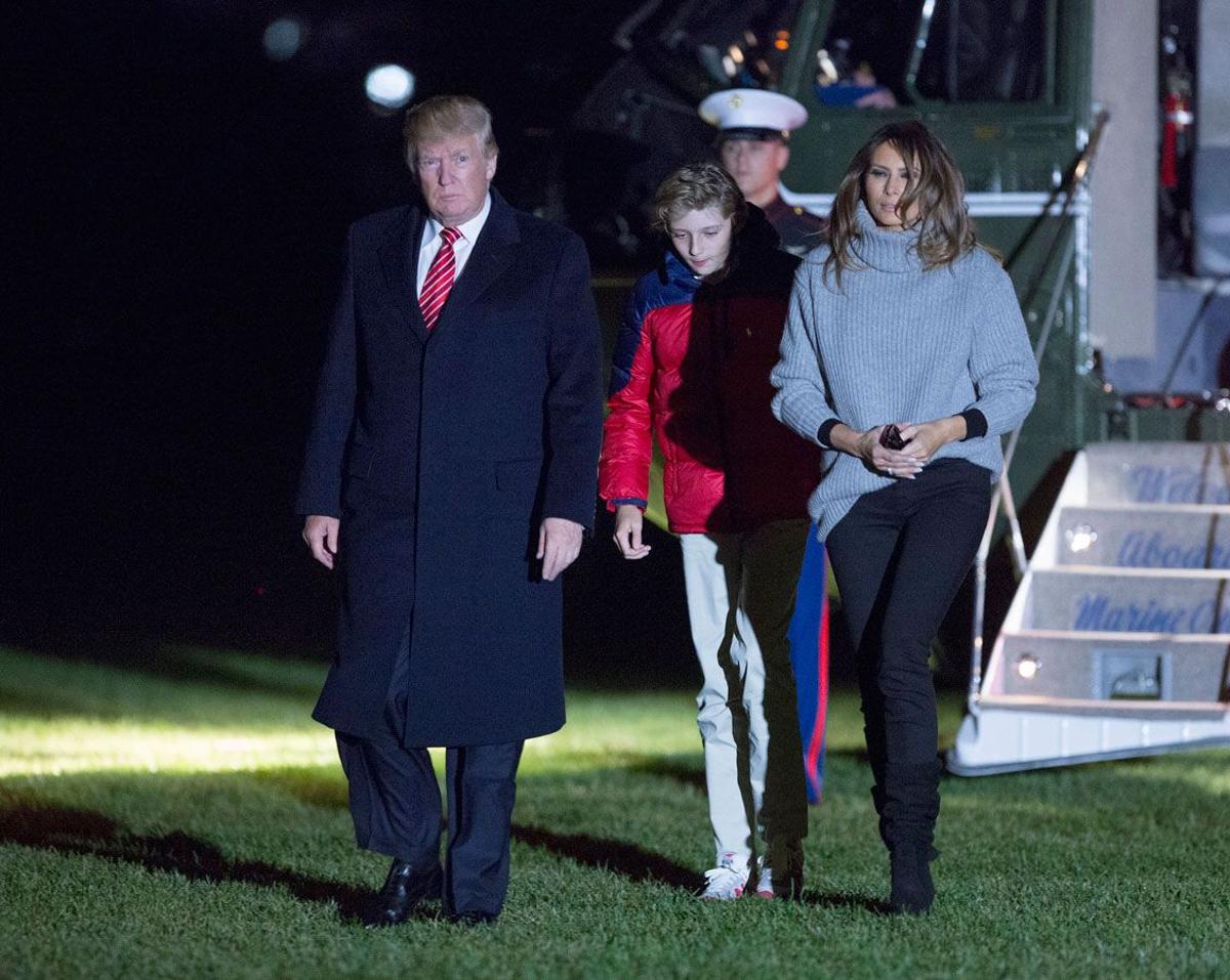 El look de Melania Trump con jersey gris, pantalones negros y botas altas de ante