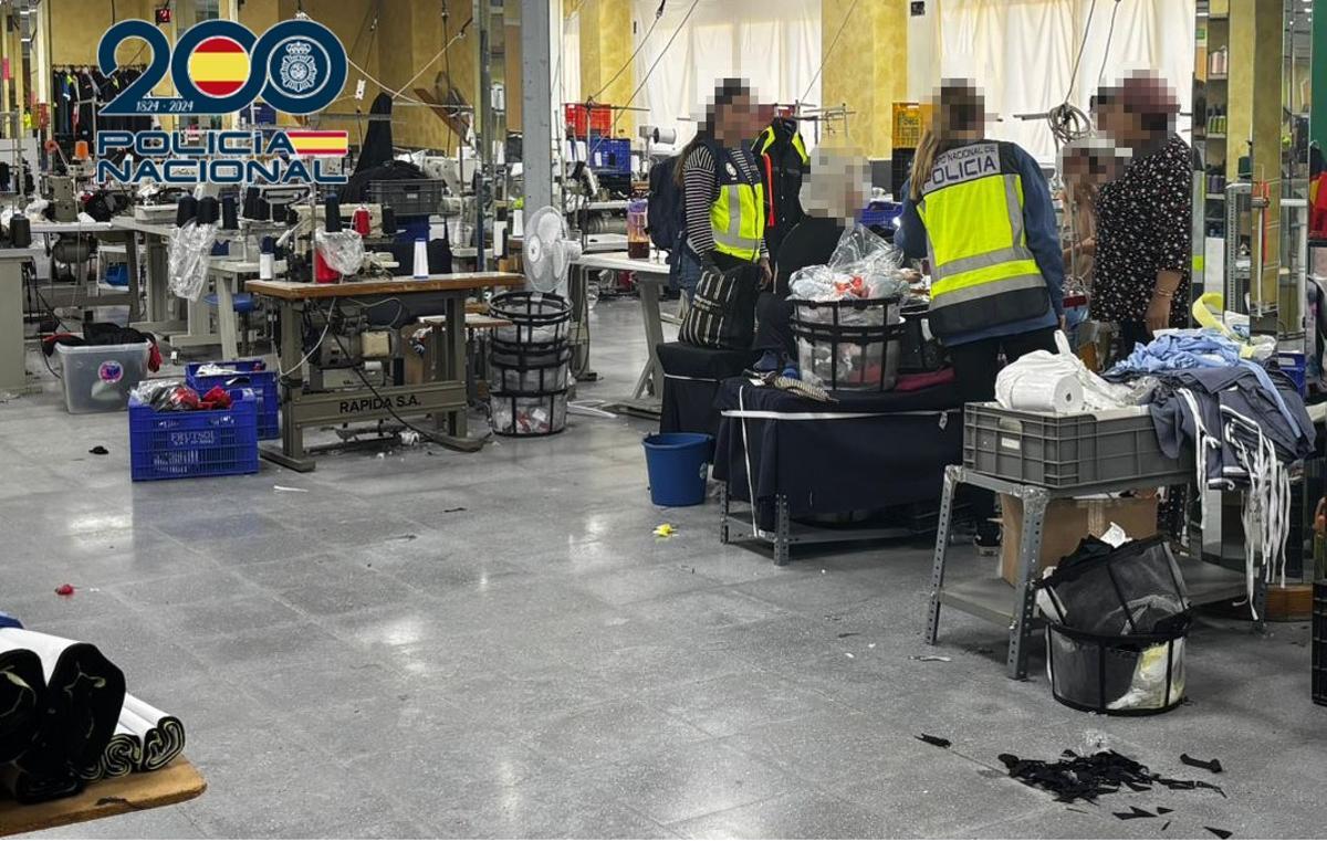 Agentes de la Policía Nacional durante la inspección al taller clandestino de textil donde se explotaba a 26 personas en situación irregular.